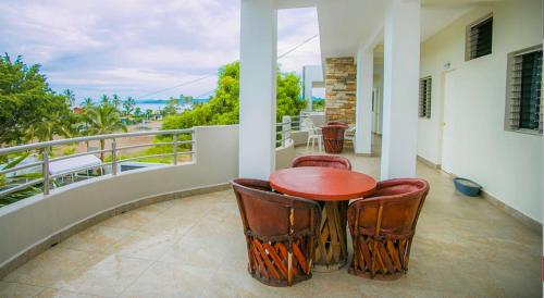 a porch with a table and chairs on a balcony at Real del Sol in Rincon de Guayabitos