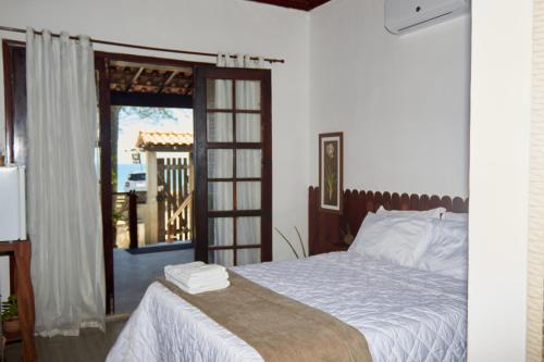 a bedroom with a bed and a sliding glass door at Hey, Brothers! in Saquarema