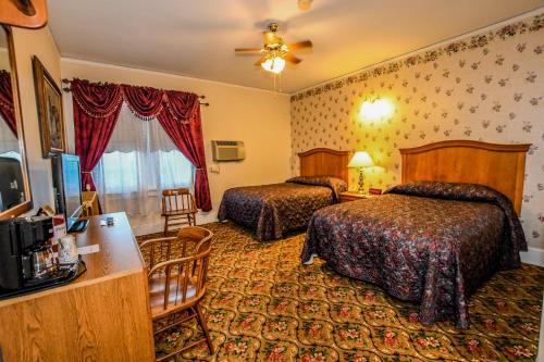 a hotel room with two beds and a television at Irma Hotel in Cody