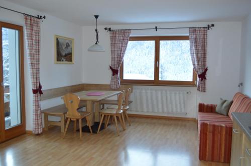 una cucina e una sala da pranzo con tavolo e sedie di Isidorhof a Dobbiaco