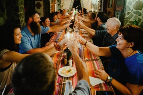 a group of people sitting around a long table drinking wine at Hotel La Casa del Mundo in Jaibalito