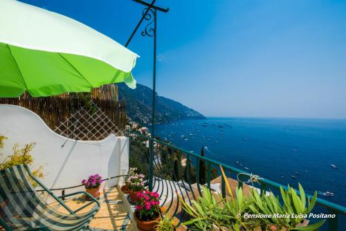 balcone con sedie, ombrellone e oceano di Pensione Maria Luisa a Positano