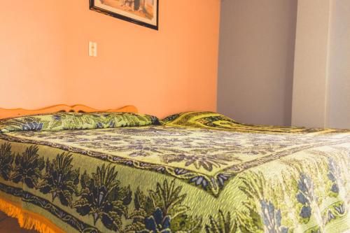 a bed in a bedroom with a blanket on it at Hotel Felicina in Jeric&oacute;