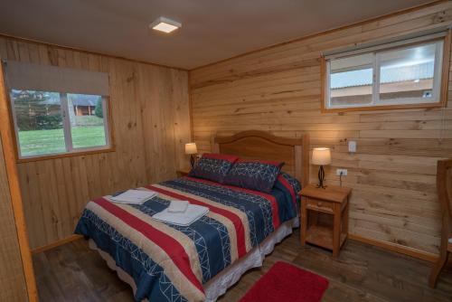 1 dormitorio con 1 cama en una cabaña de madera en Rilamar Cabañas, en Puerto Varas