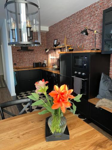 Auszeit-Appartement Wernigerode في فيرنيغيروده: مزهرية مع الزهور على طاولة في مطبخ