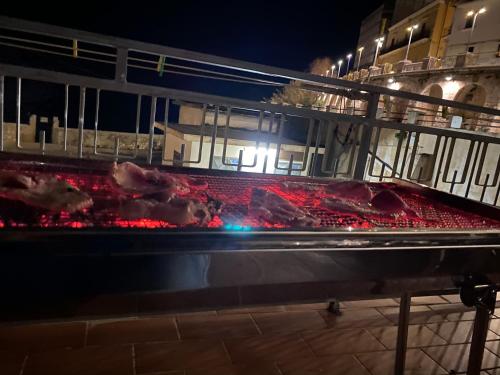 a grill with meat on top of it at night at Terrazza mare home in Rodi Garganico