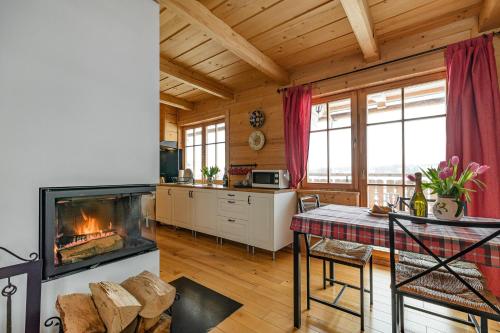 a kitchen and living room with a fireplace in a log cabin at Sun&Ski Maciejówka in Białka Tatrzańska