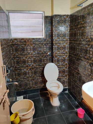 a bathroom with a toilet and a sink at Bedspace Living in Udupi