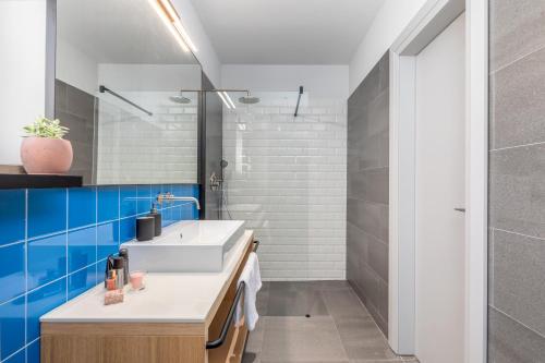 a bathroom with a white sink and blue tiles at Villa Voliera, Papafigo Camping in Vodnjan