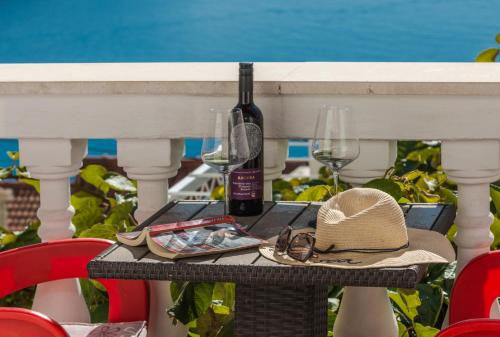 una mesa de picnic con una botella de vino y copas en Amazing view Apartment and Rooms Dragan, en Dubrovnik