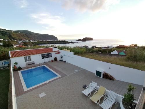a villa with a swimming pool and the ocean at Casa Pôr do Sol in Mosteiros