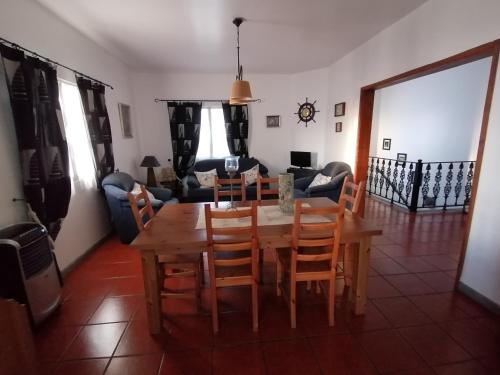 a living room with a wooden table and chairs at Casa Pôr do Sol in Mosteiros