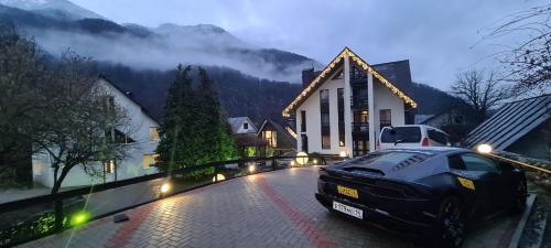 a car parked in front of a house at Неотель in Krasnaya Polyana