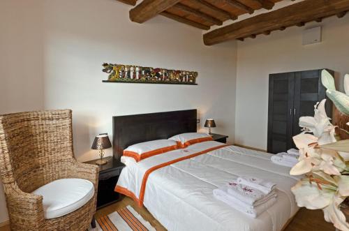 a bedroom with a large bed and a chair at Residence Prunali in Massarosa