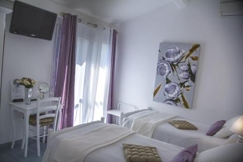 a hotel room with three beds and a window at Hôtel Le Méditerranée in Hyères