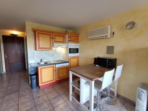 a small kitchen with a wooden table and a sink at Les Haut Du Lac in Sainte-Croix-de-Verdon