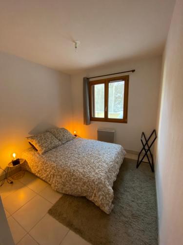 a bedroom with a bed and a window at Appartement cosy Briançon in Briançon