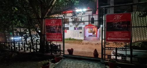 a gate with signs in front of a building at night at Nook Inn & Suites - MG ROAD METRO in Gurgaon