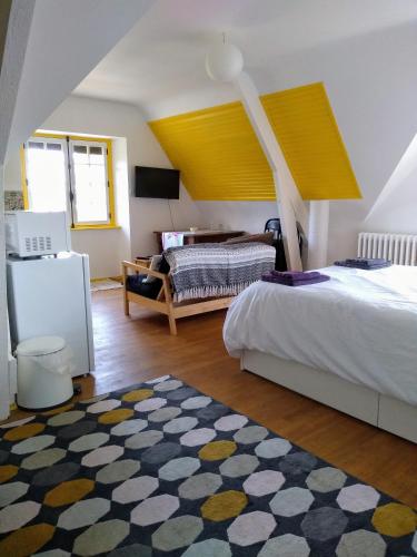 - une chambre avec un lit et un plafond jaune dans l'établissement Roz Melen, à Châteauneuf-du-Faou