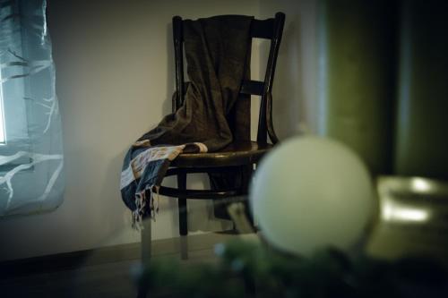 a wooden chair with a blanket sitting in a room at Radman's house in Niš