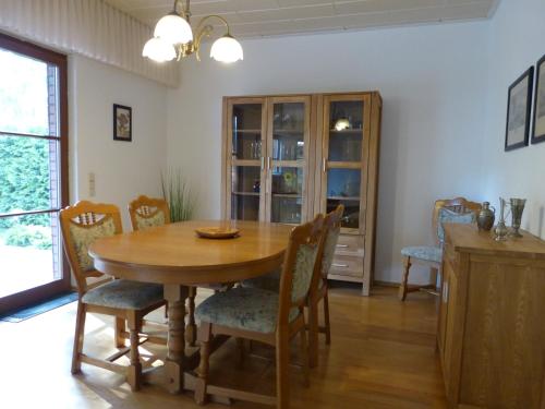 a dining room with a wooden table and chairs at Auf der Heide in Borkheide