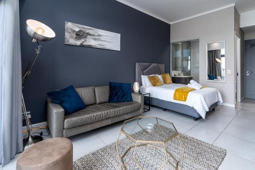a living room with a bed and a couch at Top Floor Menlyn Maine studio apartment with Stunning Views & No Load Shedding in Pretoria