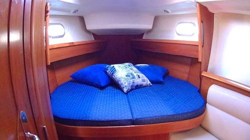a small cabin with blue pillows on a boat at Scugnizza Smeralda in Cannigione