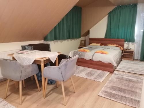 1 dormitorio con 1 cama, mesa y sillas en Ilona Ház, en Hévíz
