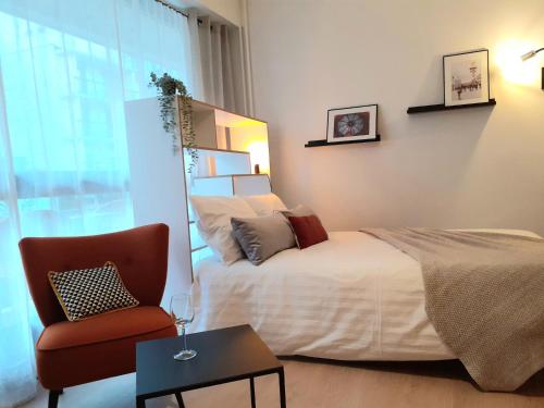 une chambre avec un lit, une chaise et une fenêtre dans l'établissement St Germain en Laye- La défense 17mn -STUDIO FIBRE -Terrasse, à Le Pecq