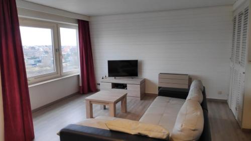 - un salon avec un canapé et une télévision dans l'établissement De Zandeters, à Oostduinkerke
