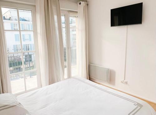 a white bedroom with a bed and a window at Appartement 6 pers. à Disneyland Paris in Chessy