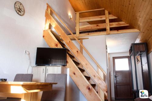 a loft bed in a tiny house with a tv at Apartman Adria 2 in Kupres