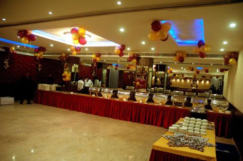 a banquet hall with a table with food and balloons at Hotel JIVA in Jamshedpur