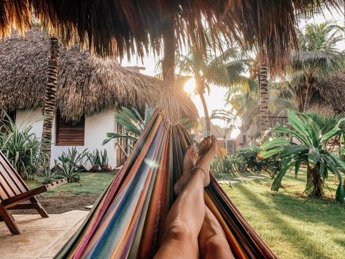 a person laying in a hammock in a resort at Paredon Surf House in El Paredón Buena Vista