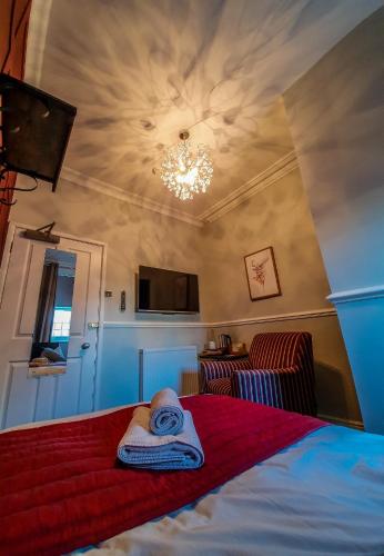 a bedroom with a bed with a hat on it at Abbey Court Guest House in Carlisle