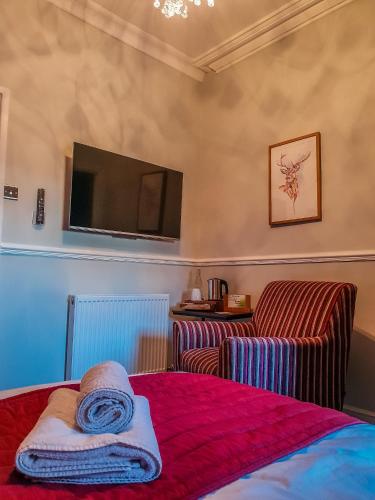 a hotel room with a bed and a tv at Abbey Court Guest House in Carlisle