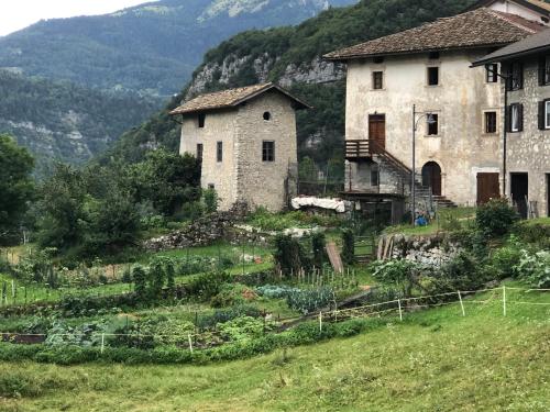 an old building and a garden in a field at Residence Aurora in Lavarone