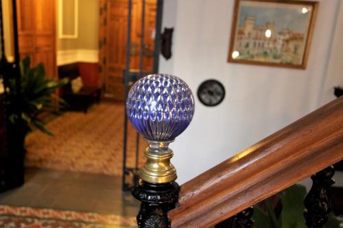 uma bola de vidro azul sobre uma mesa no corredor em Inés Casa Rural em Almodóvar del Campo