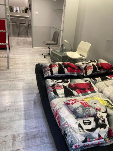 a bedroom with a bed and chairs in it at Marilyn City Center in Pécs