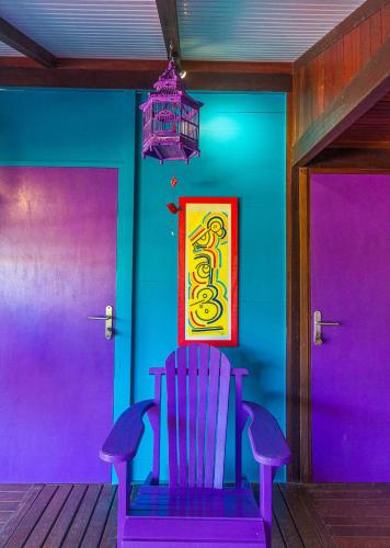 a purple chair in a room with a chandelier at Piton Bungalows Ecolodges in Deshaies