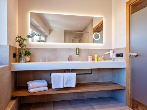 ein Bad mit einem Waschbecken und einem Spiegel in der Unterkunft Stadthotel EGGERBRÄU in Imst