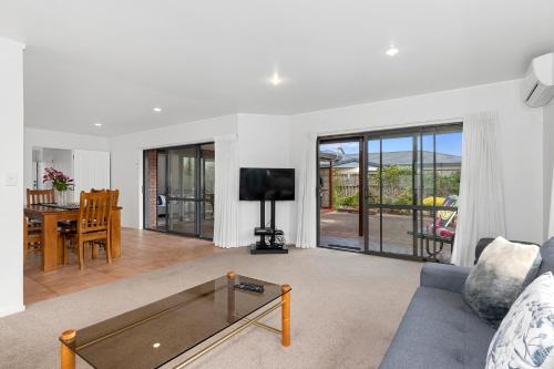 a living room with a couch and a table at Bream Bay Bach - Ruakaka Holiday Home in Ruakaka