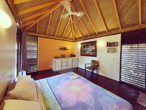 a living room filled with furniture and a large window at Fare Tokoau Moorea in Moorea