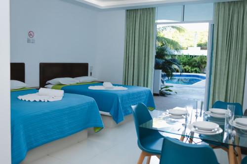 a hotel room with two beds and a table and chairs at Costa Madero Resort in Los Ayala