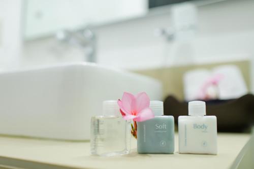 a group of spa items with a pink flower on a counter at Costa Madero Resort in Los Ayala