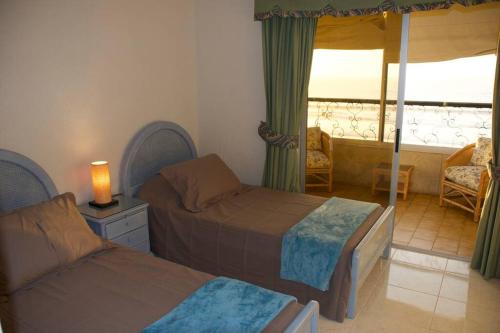 a bedroom with two beds and a balcony at Amplio y acogedor departamento frente al Mar Sector 4Esquinas in La Serena