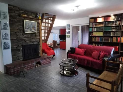 a living room with a red couch and a fireplace at Vila Ana in Donja Ralja