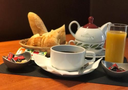 a cup of coffee and a cup of orange juice and bread at BAR HOTEL DU CENTRE (BDC) in Montrevel-en-Bresse