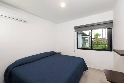 a bedroom with a blue bed and a window at DEPARTAMENTO EN PLANTA BAJA CON TERRAZA in Mazatlán