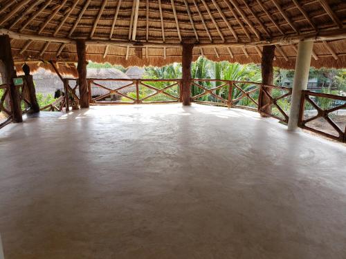 a large room with a large concrete floor with a straw roof at Casa Hridaya Hotel Boutique in Holbox Island